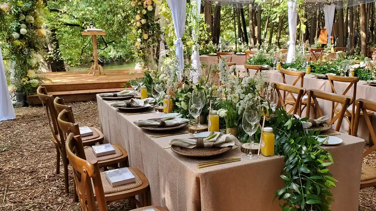 A long dinner table set among the trees for an outdoor kosher catered meal